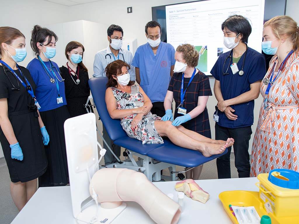 Trainees and consultant in simulation suite with patient